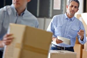 man watching moving company employees pack up a house