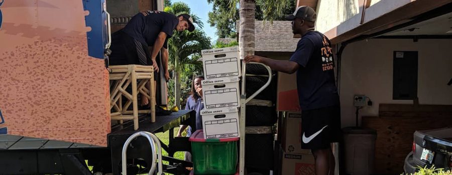 Tropic Moving employees putting boxes into the moving truck