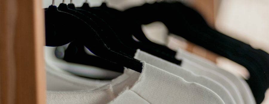 white shirts hanging on black hangers