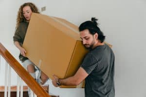 Man and Woman Moving Boxes Downstairs Together