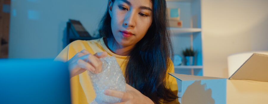 image of woman packing fragile items in bubble wrap